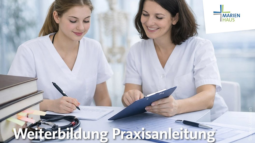 Zwei Frauen in weißer Arbeitskleidung sitzen an einem Tisch mit Aktenordnern und Schreibmaterialien